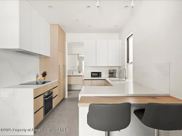a kitchen with stainless steel appliances a sink a stove a refrigerator cabinets and a counter space