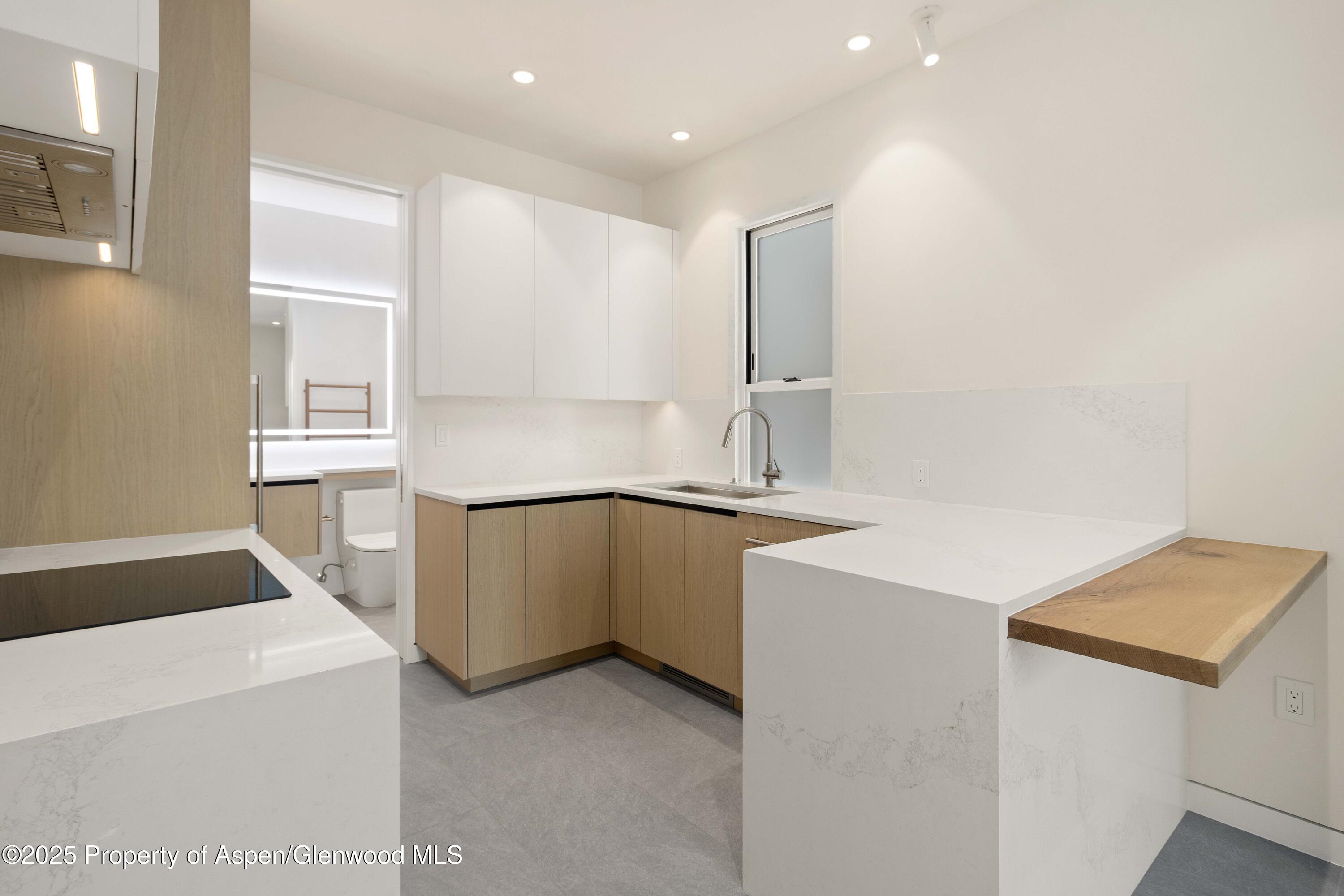211 West Main Street, Unit 101 Aspen, CO 81611 - Photo 5 of 13 a kitchen that has a sink and a stove in it