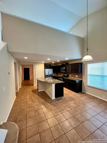 a kitchen with stainless steel appliances a sink a stove a microwave a counter top space and cabinets