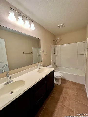 a bathroom with a glass door shower and closet