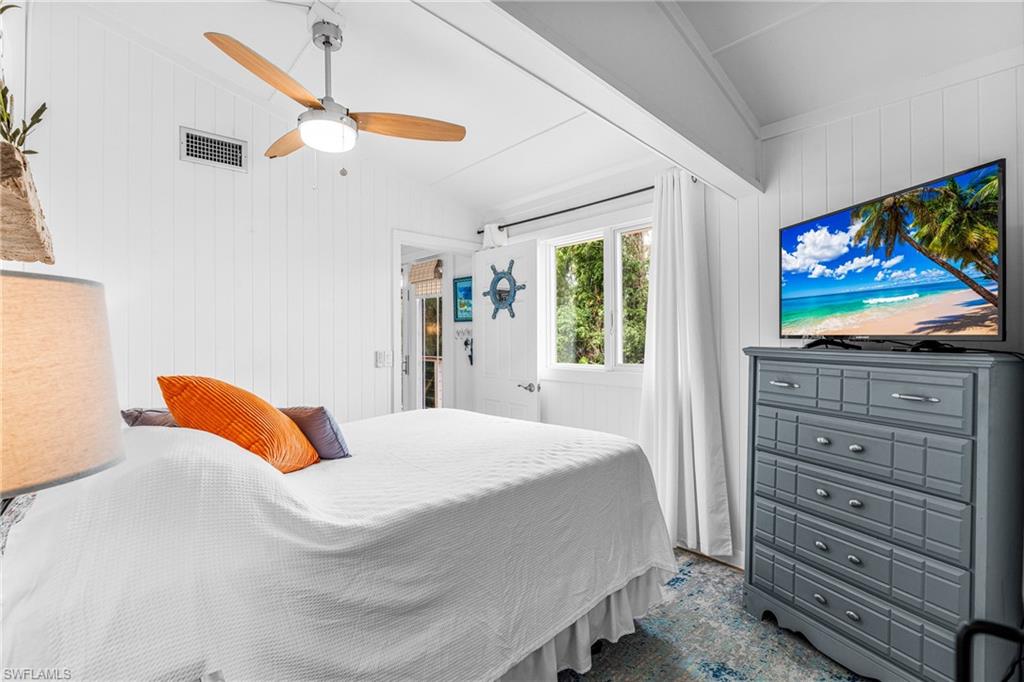 10931 Russell Road Bokeelia, FL 33922 - Photo 16 of 50 a bedroom with a bed and a flat screen tv