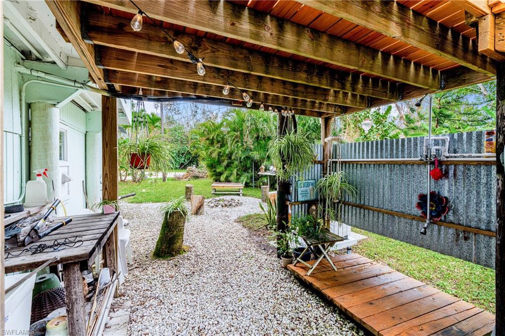 10931 Russell Road Bokeelia, FL 33922 - Photo 36 of 50 a view of a chairs and table in the patio with a small yard