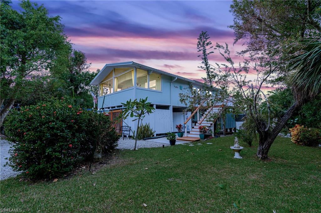 10931 Russell Road Bokeelia, FL 33922 - Photo 49 of 50 a front view of a house with a yard