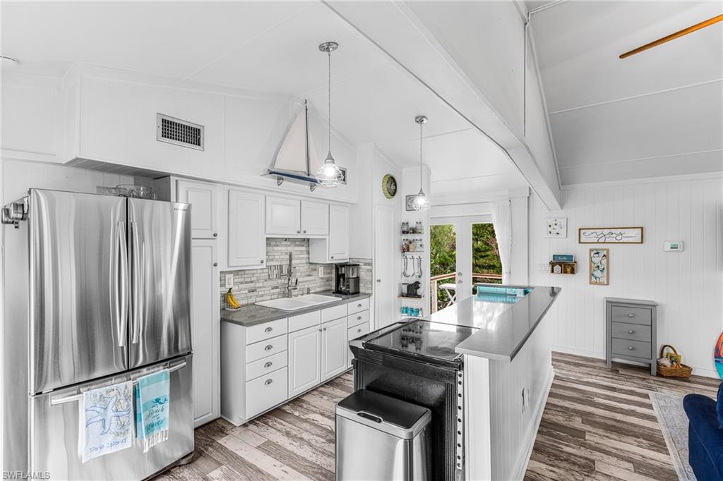 10931 Russell Road Bokeelia, FL 33922 - Photo 5 of 50 a kitchen with kitchen island white cabinets and refrigerator