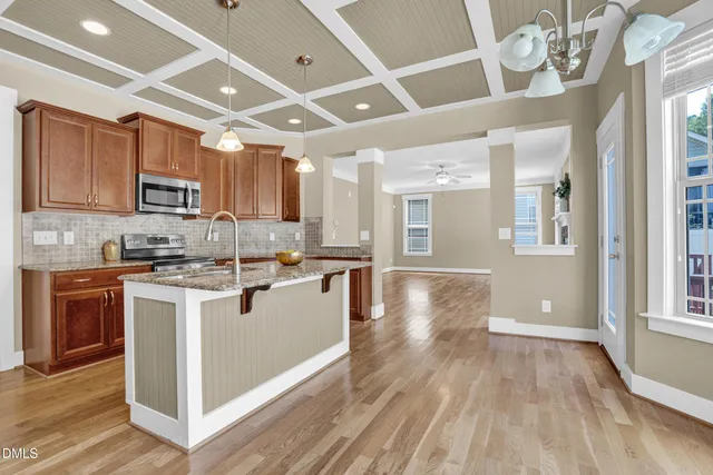 a view of an empty room with wooden floor fireplace and a window