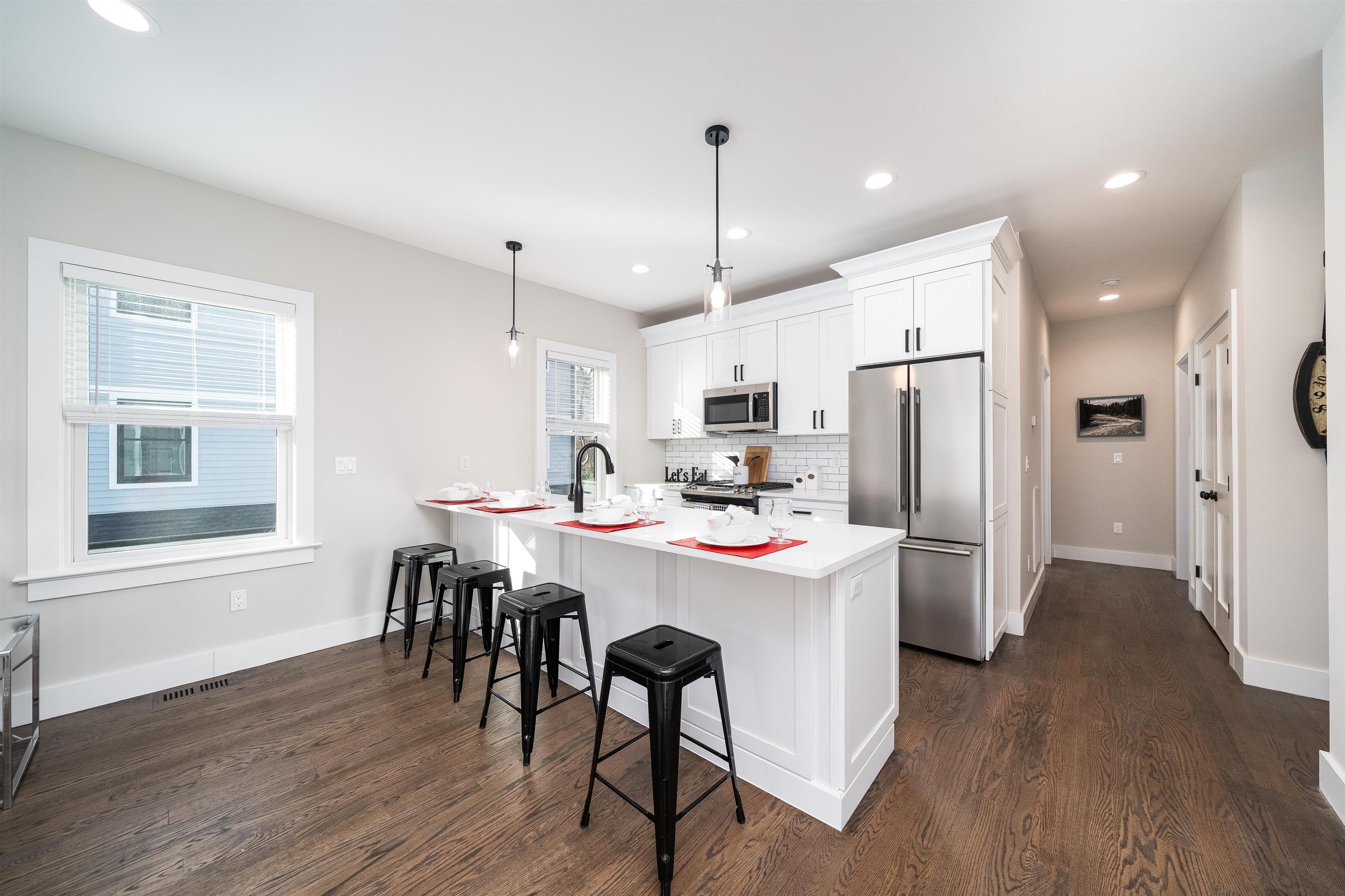 20 Orchard Street, Unit 1 Morristown, NJ 07960 - Photo 6 of 25 a kitchen with stainless steel appliances a dining table chairs refrigerator and microwave