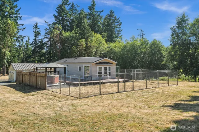 a view of a house with a backyard and a large tree