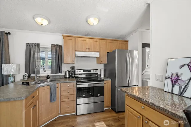 a kitchen with stainless steel appliances granite countertop a sink stove and refrigerator