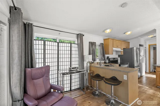 a kitchen with a stove a refrigerator and a couch