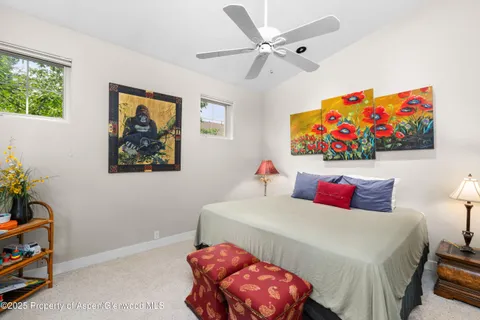 a bedroom with a bed a wall painting and a potted plant