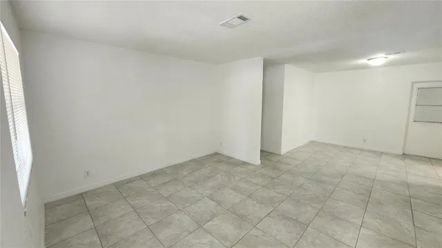 an empty room with white walls and tiles