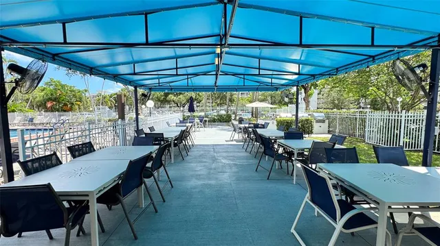 a view of a patio with table and chairs under an umbrella
