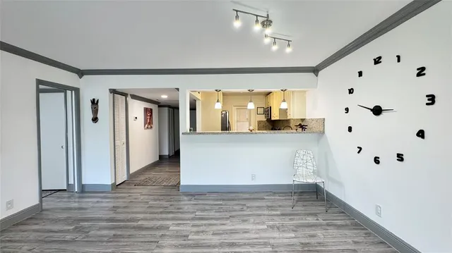 a view of a kitchen with kitchen island white cabinets and wooden floor