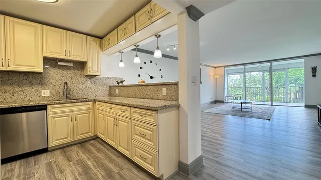 a kitchen with wooden cabinets and wooden floor