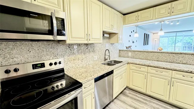 a kitchen with stainless steel appliances a stove a sink and a microwave