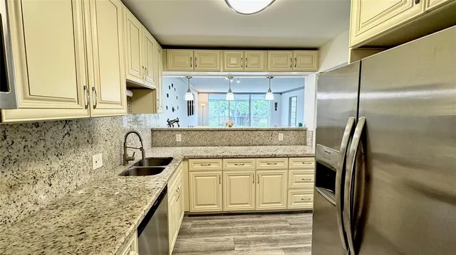 a kitchen with stainless steel appliances granite countertop a sink stove and refrigerator