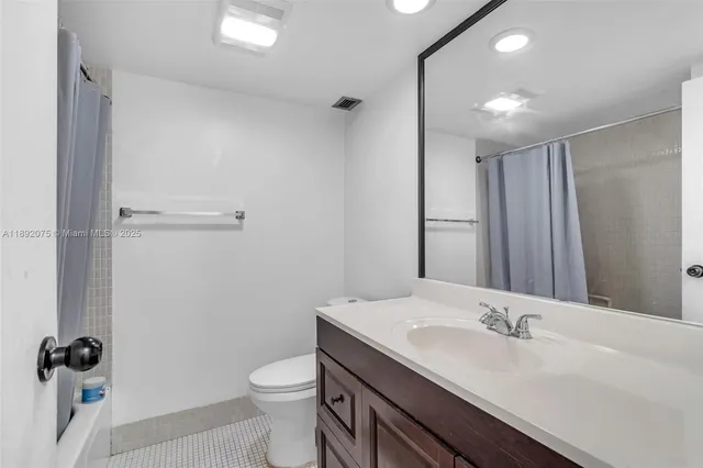 a bathroom with a sink a toilet a mirror and shower