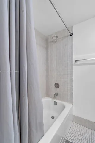 a bathroom with a tub a sink and a shower
