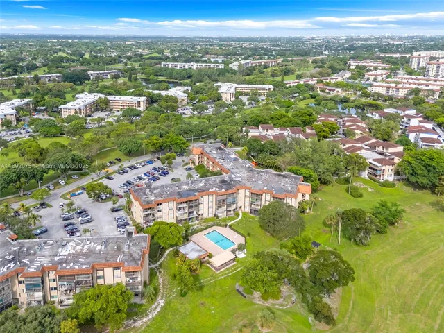 an aerial view of residential houses with outdoor space and trees