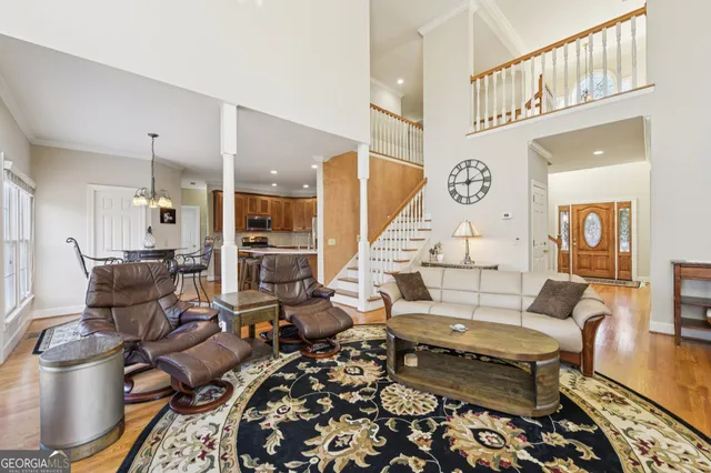 a kitchen with stainless steel appliances granite countertop a refrigerator a stove top oven a sink dishwasher and white cabinets with wooden floor