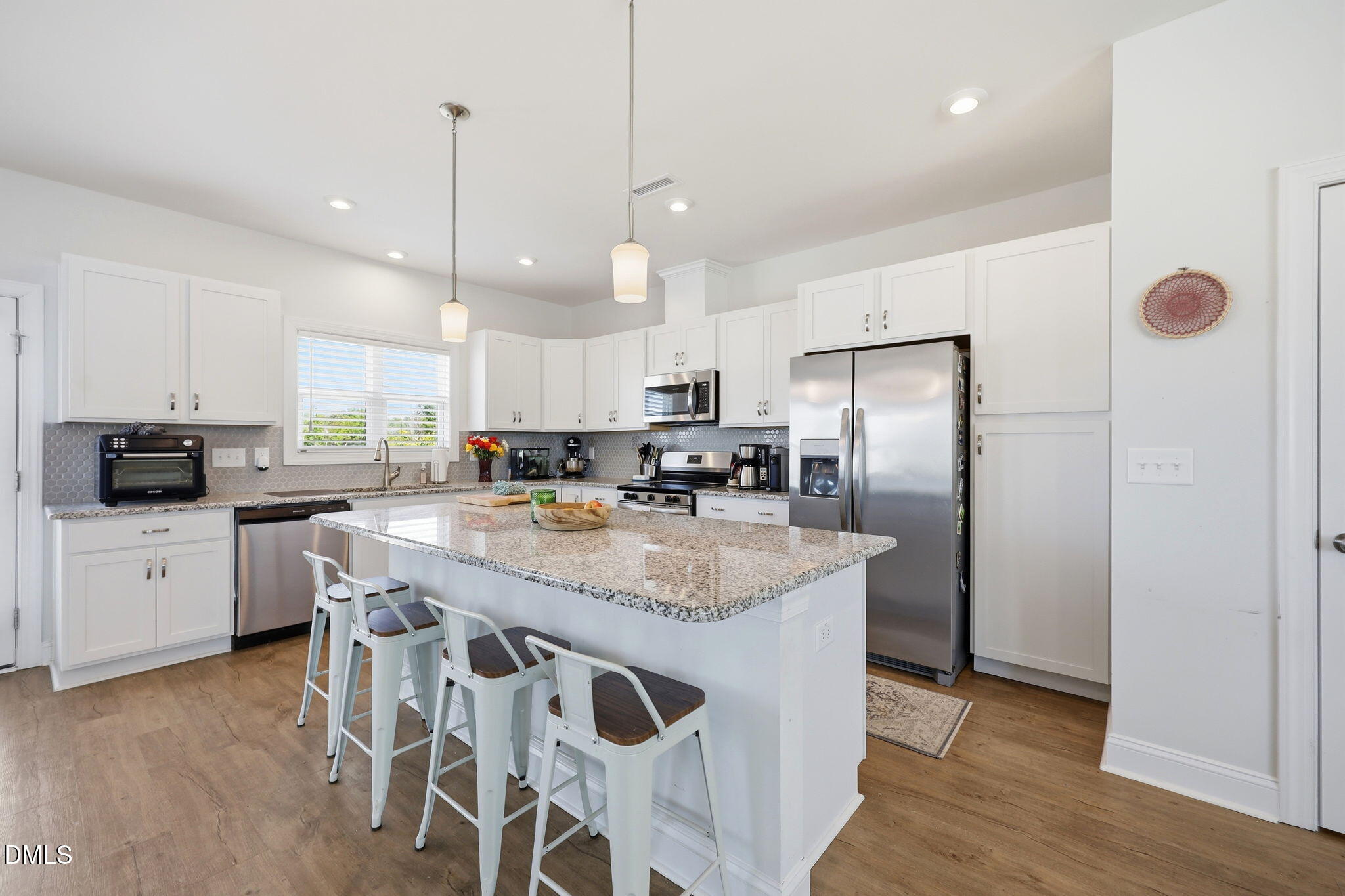 104 Kavanaugh Road Wake Forest, NC 27587 - Photo 11 of 36 a kitchen with stainless steel appliances granite countertop a refrigerator a sink dishwasher a stove and white cabinets with wooden floor