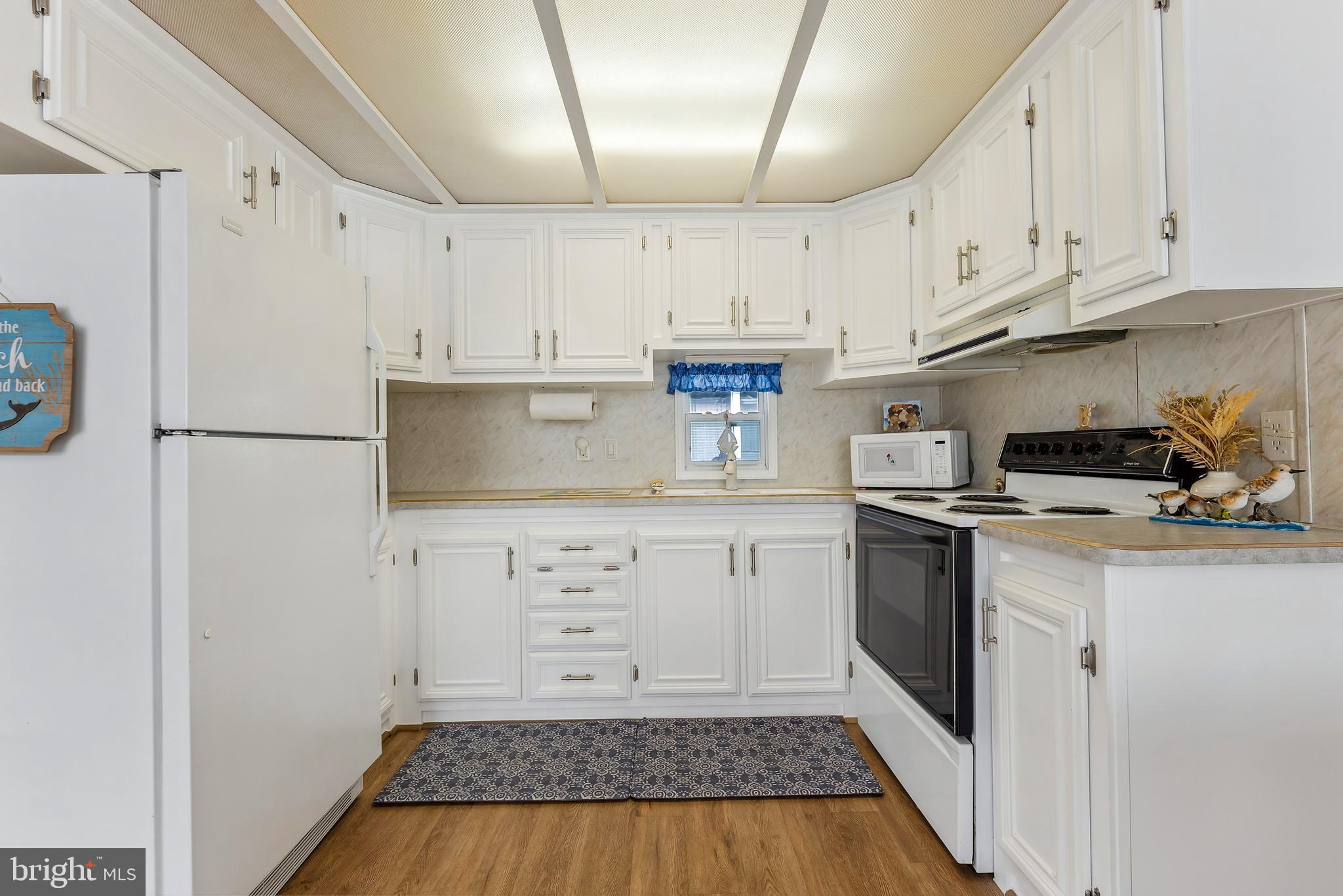 169 Edson, Unit 169 Woodbine, NJ 08270 - Photo 3 of 45 a kitchen with white cabinets and white appliances