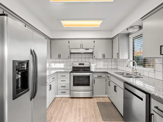 a kitchen with stainless steel appliances a stove sink and refrigerator