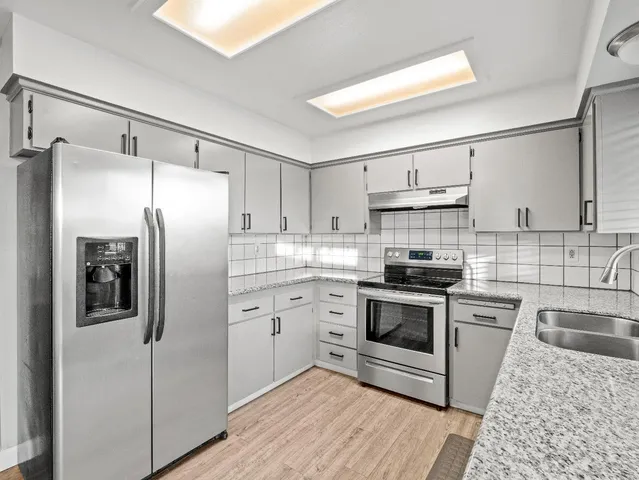 a kitchen with stainless steel appliances cabinets a sink and a counter top space
