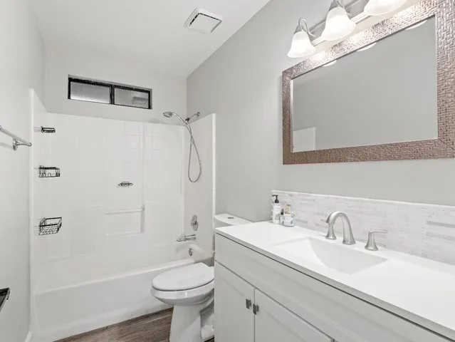 a bathroom with a sink a toilet and shower