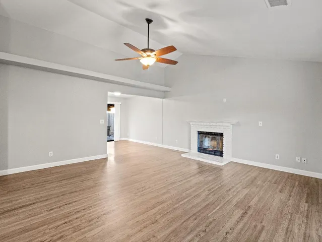 a view of an empty room with a window and a fireplace