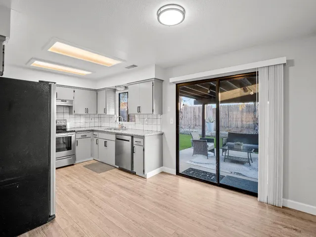 a kitchen with a refrigerator a sink and a stove top oven
