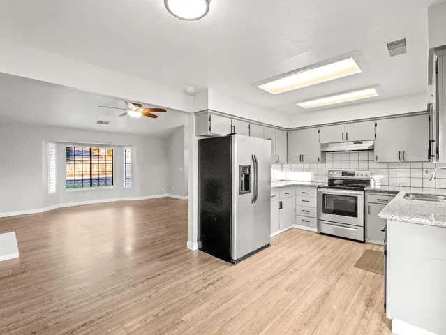 a kitchen with stainless steel appliances a refrigerator and a stove top oven