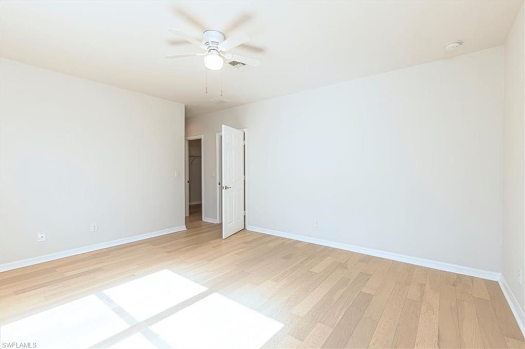 15389 Summit Pl Circle, Unit 286 Naples, FL 34119 - Photo 13 of 29 Spare room with light wood-style floors and ceiling fan
