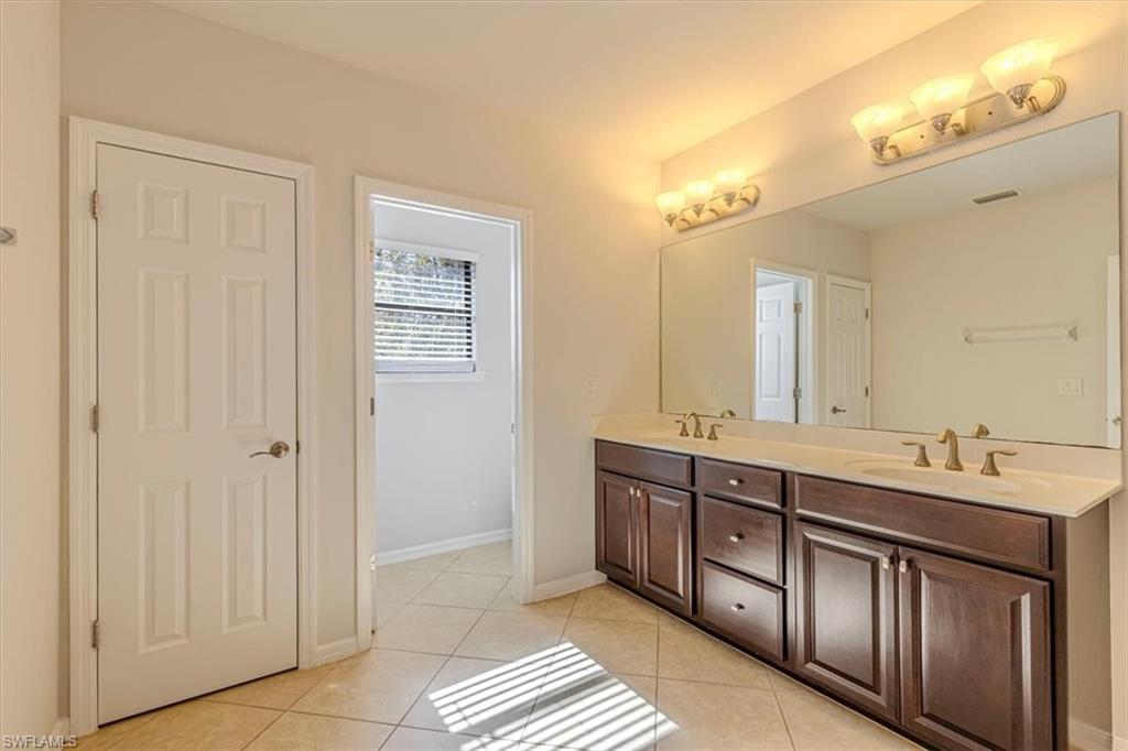 15389 Summit Pl Circle, Unit 286 Naples, FL 34119 - Photo 14 of 29 Full bath with double vanity and light tile patterned floors