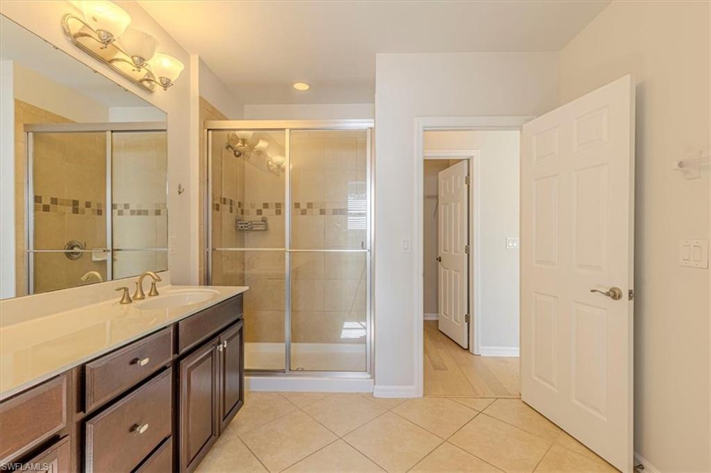 15389 Summit Pl Circle, Unit 286 Naples, FL 34119 - Photo 15 of 29 Full bathroom with vanity, light tile patterned floors, a shower stall, and recessed lighting