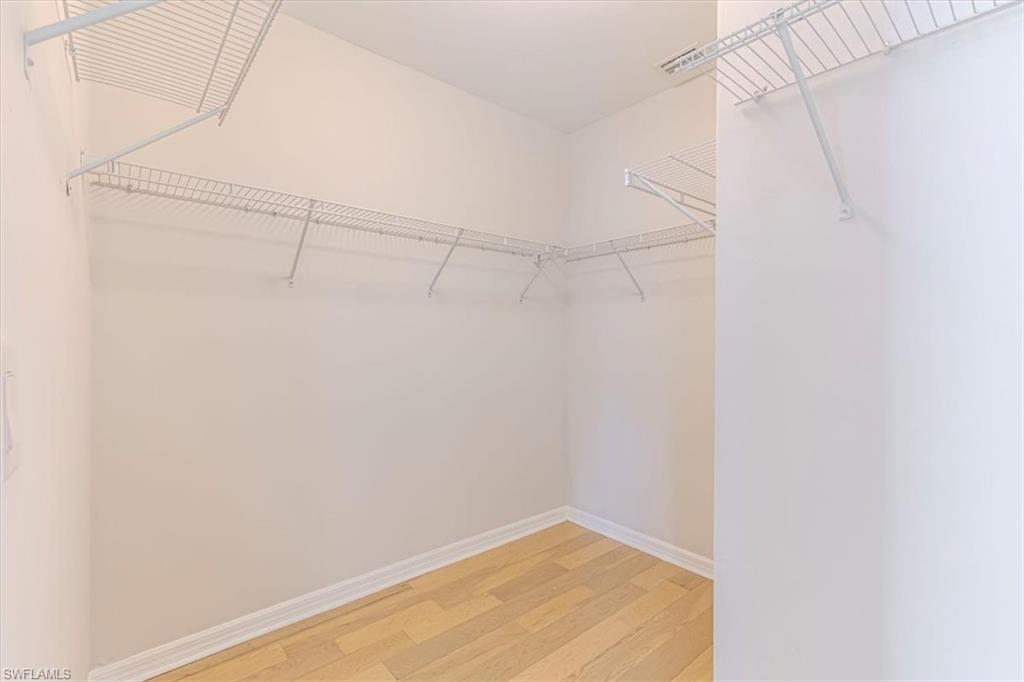 15389 Summit Pl Circle, Unit 286 Naples, FL 34119 - Photo 18 of 29 Walk in closet with light wood finished floors