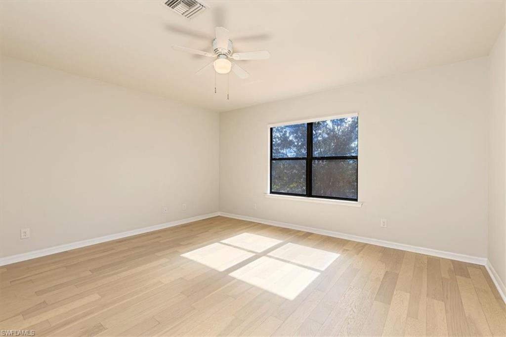 15389 Summit Pl Circle, Unit 286 Naples, FL 34119 - Photo 19 of 29 Empty room with a ceiling fan and light wood-type flooring