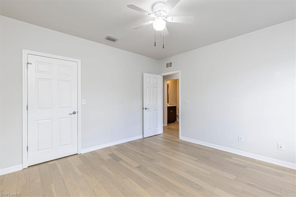 15389 Summit Pl Circle, Unit 286 Naples, FL 34119 - Photo 20 of 29 Unfurnished bedroom with a ceiling fan and light wood-type flooring