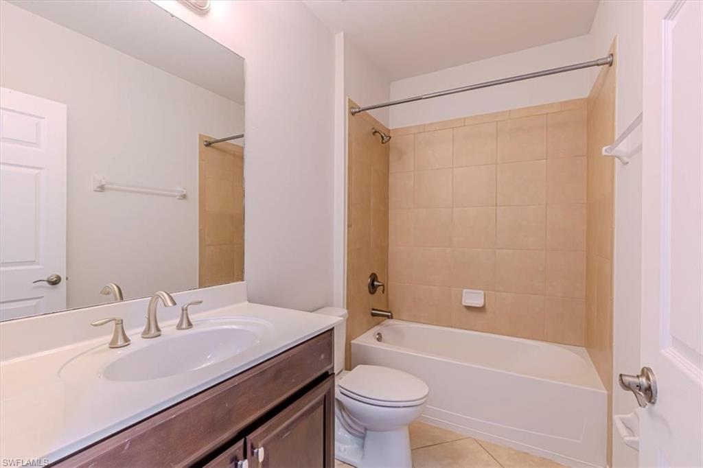 15389 Summit Pl Circle, Unit 286 Naples, FL 34119 - Photo 21 of 29 Full bathroom with vanity, light tile patterned flooring, and bathing tub / shower combination