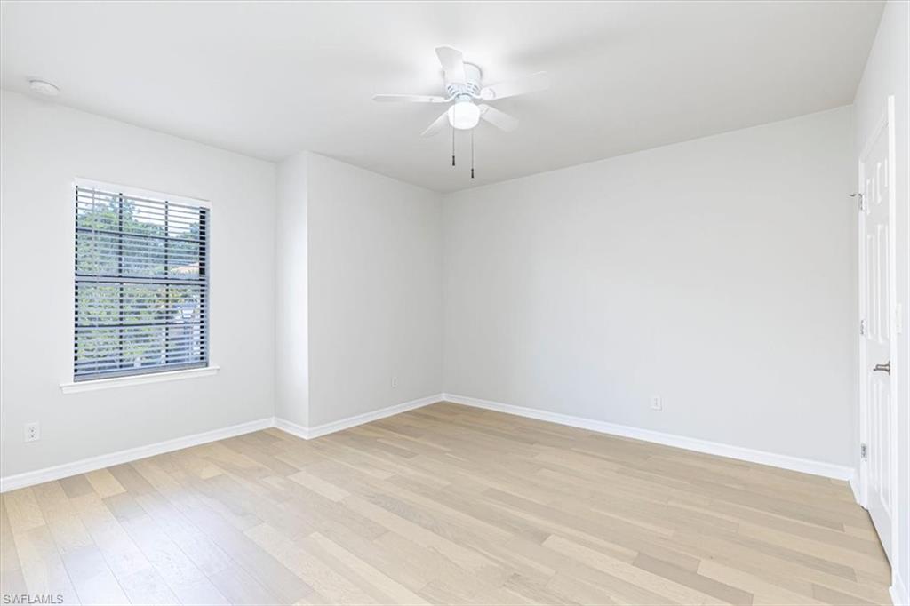 15389 Summit Pl Circle, Unit 286 Naples, FL 34119 - Photo 22 of 29 Unfurnished room with ceiling fan and light wood-style floors