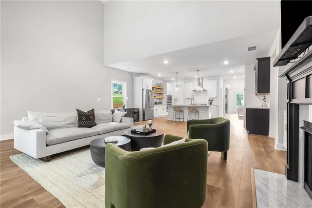 a living room with furniture and a view of kitchen