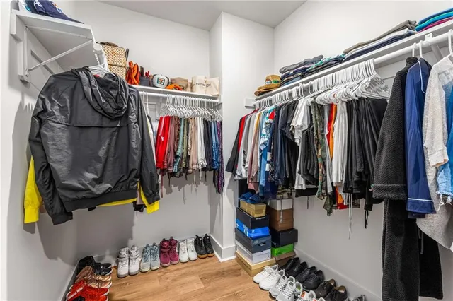 a view of walk in closet with clothes and shoes