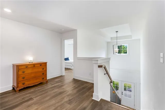 a view of an empty room with wooden floor and stairs