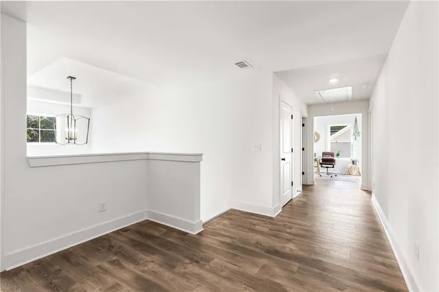 a view of a hallway with wooden floor and closet
