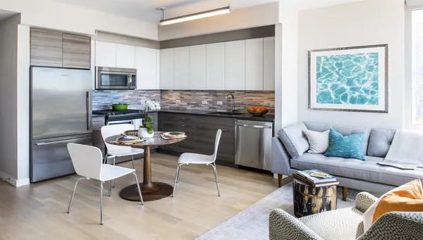 a kitchen with a dining table chairs and refrigerator
