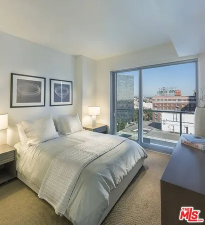 a bedroom with bed and a large window