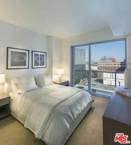 a bedroom with bed and a large window