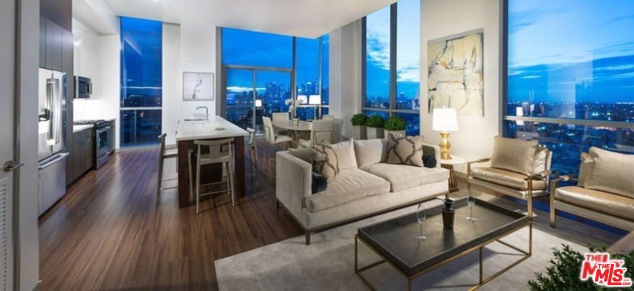 3033 Wilshire Boulevard, Unit 1707 Los Angeles, CA 90020 - Photo 17 of 32 a living room with furniture a fireplace and a dining table with wooden floor