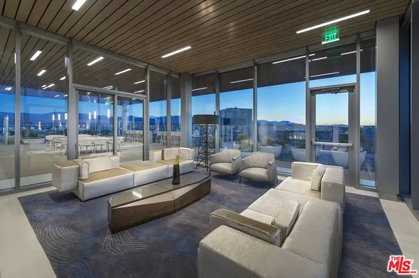 a living room with furniture wooden floor and kitchen view