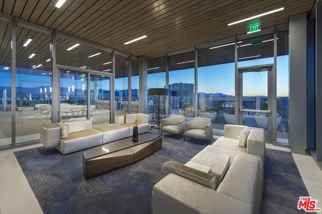 a living room with furniture wooden floor and kitchen view